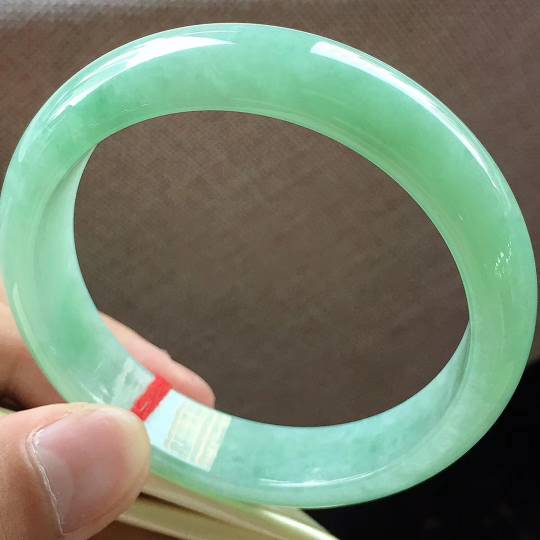 冰糯果绿满色正圈手镯
，圈口57*13.5*7.7mm
细腻水润，质地均匀，种老起胶，完美